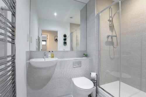 a bathroom with a toilet and a sink and a shower at Elliot Oliver - Stylish 2 Bedroom Apartment With Parking In The Docks in Gloucester