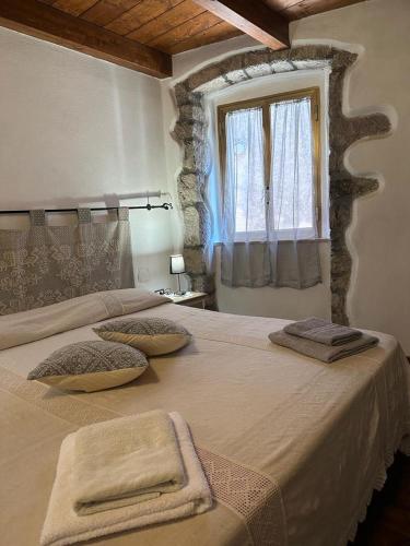 1 dormitorio con 2 camas y ventana en B&B Pudzones, en Santu Lussurgiu
