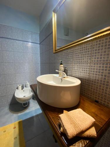 y baño con lavabo y espejo. en B&B Pudzones, en Santu Lussurgiu