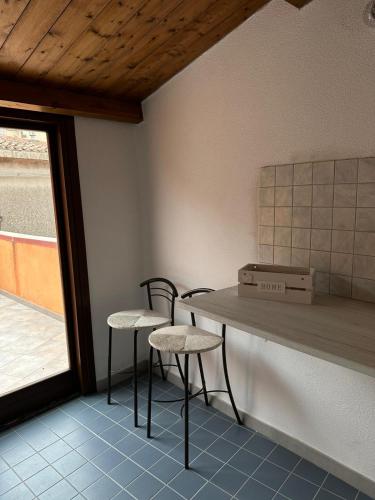 cocina con 2 sillas, mesa y ventana en B&B Pudzones, en Santu Lussurgiu