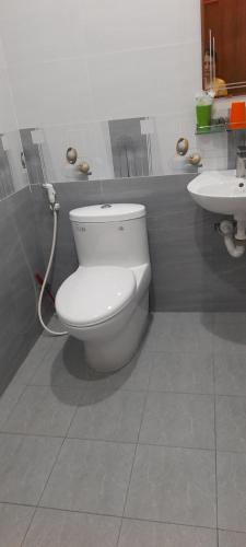 een badkamer met een wit toilet en een wastafel bij Nhà Nghỉ Kim Cương in Rach Gia
