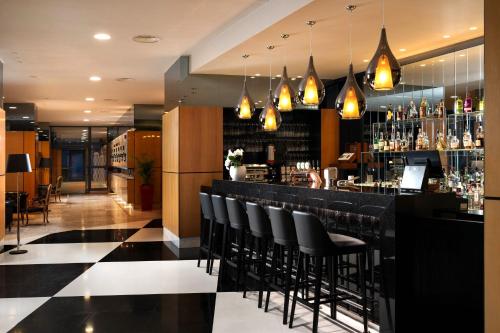 a bar with black chairs in a restaurant at Ana Hotels Europa Eforie Nord in Eforie Nord