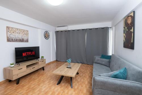a living room with a couch and a tv at Napa Centrale Suites in Ayia Napa