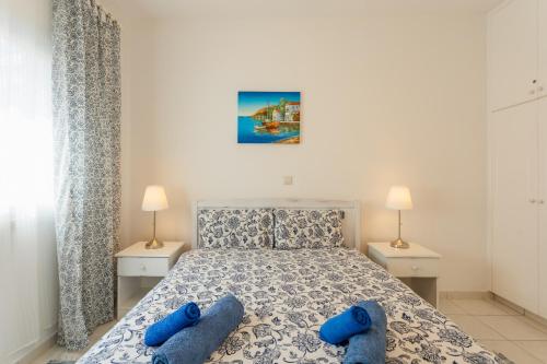 ein Schlafzimmer mit einem Bett mit blauen Hausschuhen darauf in der Unterkunft Regina Gardens Lovely Apartment in Paphos City