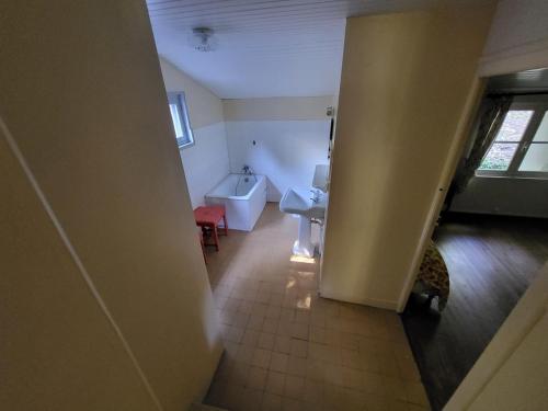 ein Badezimmer mit einer weißen Badewanne und einem Waschbecken in der Unterkunft 607-Manoir de Pompren in Esquibien