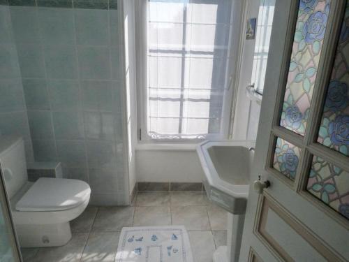 ein Badezimmer mit Toilette und Waschbecken und einem Fenster in der Unterkunft 680-Villa Kerven-Pors Tarz in Primelin