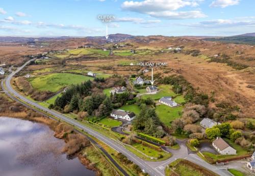 an aerial view of a house with a road and a river at Teach Eile, Clifden in Clifden