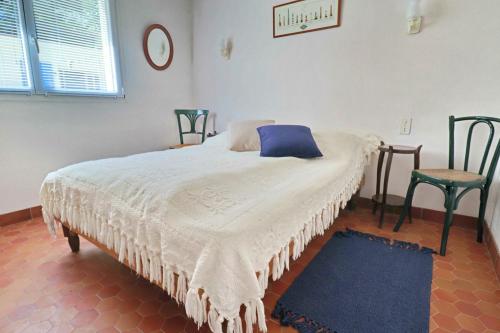 une chambre avec un lit avec un oreiller bleu et deux chaises dans l'établissement 685-Ty Kastel Coz a 50m de la mer, à Beuzec-Cap-Sizun