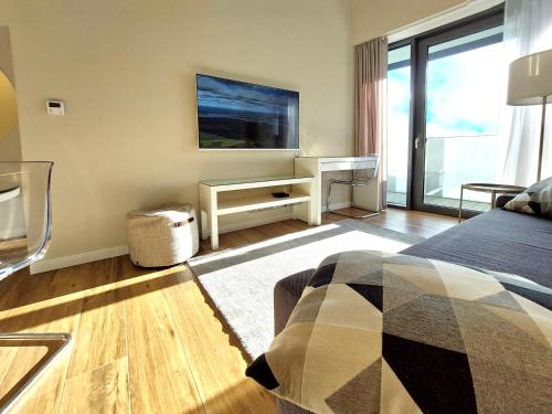 a bedroom with a bed and a desk with a television at Hanza Tower STETT-INN Business & Holiday in Szczecin