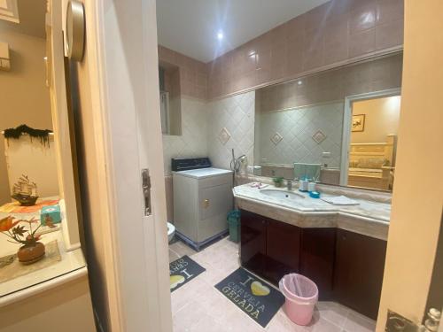 ein Badezimmer mit einem Waschbecken und einem großen Spiegel in der Unterkunft Garden city 3 bedroom apartment in Kairo