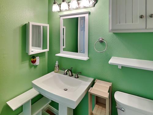 La salle de bains verte est pourvue d'un lavabo et d'un miroir. dans l'établissement Seascape 1313 - Pineapple Island, à Galveston