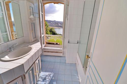 a bathroom with a sink and a window at 687-Villa Kerguelen a 100m de la plage in Audierne