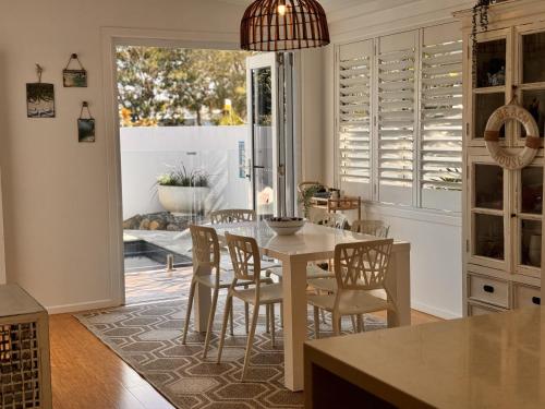 a kitchen with a table and chairs and a dining room at Gold Coast-Miami Mid-Century Beach Home With Pool in Gold Coast