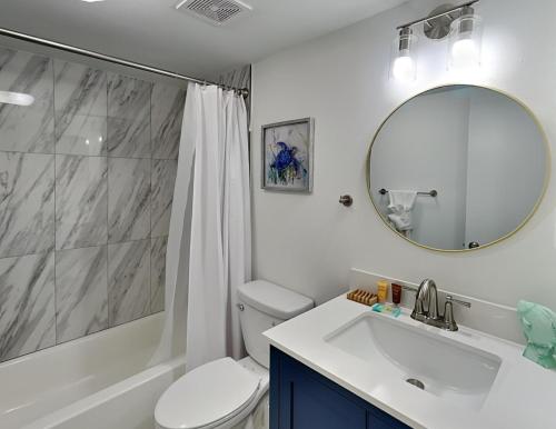 a bathroom with a toilet and a sink and a mirror at Casa Bella 105 in Fort Myers