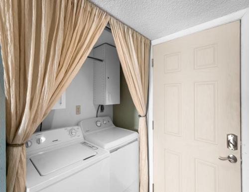a laundry room with a washer and dryer next to a door at Ocean Sands 505 in St Pete Beach
