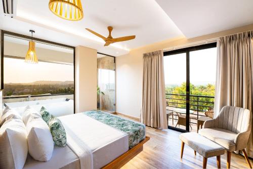 a bedroom with a bed and a large window at HOLITEL ANJUNA GOA in Anjuna