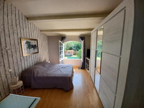 una camera da letto con un letto e una grande finestra di Magnifique villa avec piscine 10x5 m sur 1800m2 de terrain avec parking privatif cuisine recente equpee 3 chambres dont 2 parental au rdc avec wc separe pas de vis à vis terrain de petanque bbq climatisation jeux enfants a Sérignan