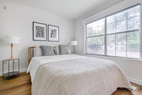 a white bedroom with a bed and a large window at Blueground Gateway pool gym near movies ATX-250 in Austin