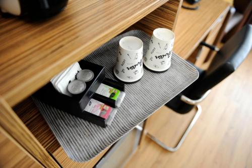 a table with two mugs and a tray with cookies at Hotel Stoller in Zürich