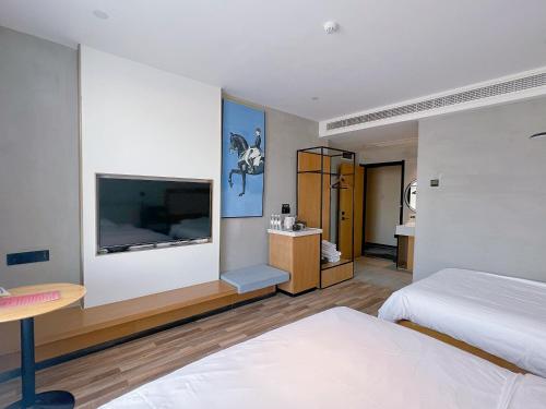1 dormitorio con 1 cama y TV de pantalla plana en 银座佳驿精致酒店（济阳汽车总站店）, en Jiyang