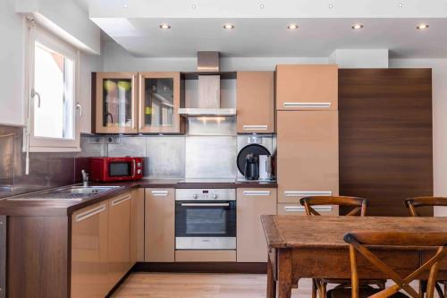 une cuisine avec des armoires en bois et une table en bois dans l'établissement Appartement au Touquet - 65m2 proche de la mer et du marché, à Le Touquet-Paris-Plage