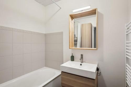 bagno con lavandino, vasca e specchio di Le Montigny Chic a Montigny-le-Bretonneux