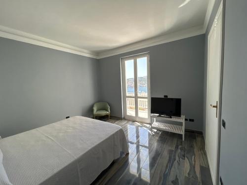a white bedroom with a bed and a television at B&B Ponza Suite in Ponza