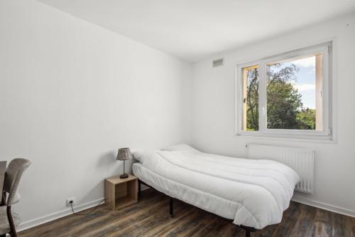 una camera bianca con un letto e una finestra di Le Montigny Chic a Montigny-le-Bretonneux