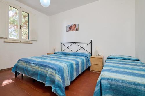 a bedroom with two beds and a window at Mare Etrusco 5 in Populonia