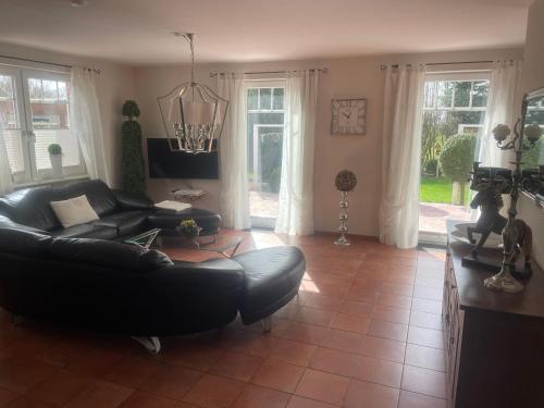 Upgant-SchottにあるFerienhaus Mare Frisicumのリビングルーム(黒い革張りのソファ、椅子付)