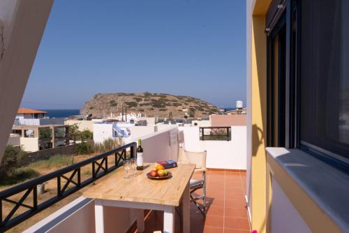 a balcony with a table with a bowl of fruit on it at Chara's Residence in Mochlos
