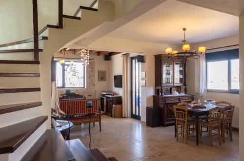 a dining room and living room with a table and chairs at Chara's Residence in Mochlos
