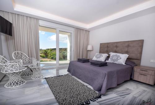 マルベーリャにあるExquisite and Modern villa near beach with Heated pool!のベッドルーム1室(ベッド1台、大きな窓付)