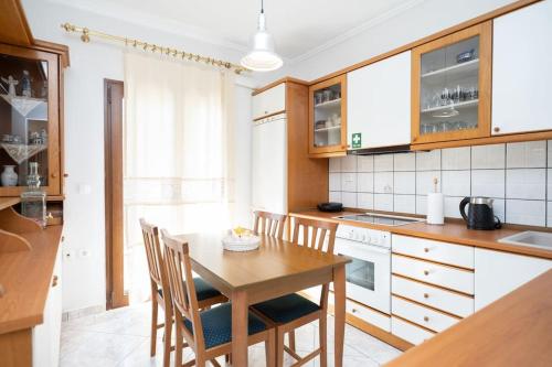 a kitchen with a wooden table and chairs in it at Romance Dream Meteora 1 in Kalabaka