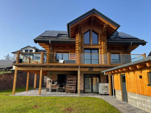 ein großes Holzhaus mit einem Dach in der Unterkunft Ferienwohnung Uplandblockhaus in Willingen