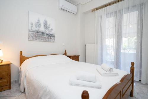 a bedroom with a white bed and a window at Romance Dream Meteora 1 in Kalabaka