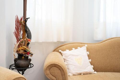 a couch with a pillow and a vase with a plant at Romance Dream Meteora 1 in Kalabaka