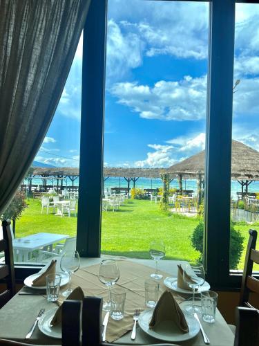 een tafel met wijnglazen en uitzicht op de oceaan bij Hotel KASHTA in Pogradec