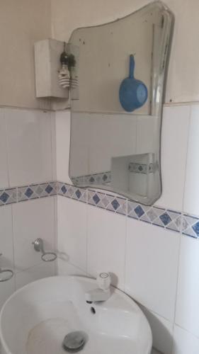 La salle de bains est pourvue d'un lavabo, d'un miroir et de toilettes. dans l'établissement Heaven Villa colombo, à Colombo
