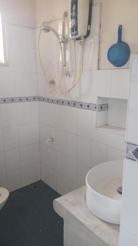 La salle de bains blanche est pourvue d'un lavabo et d'une douche. dans l'établissement Heaven Villa colombo, à Colombo