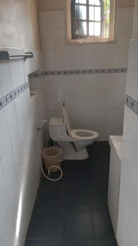 La salle de bains est pourvue de toilettes, d'un lavabo et d'une fenêtre. dans l'établissement Heaven Villa colombo, à Colombo