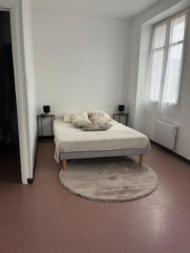 Ce lit se trouve dans un dortoir blanc doté de 2 fenêtres. dans l'établissement Résidence du lévezou, à Salmiech