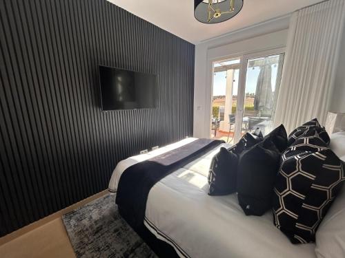 1 dormitorio con 1 cama con almohadas blancas y negras en Impeccable 2-Bed Apartment in Alhama de Murcia, en Alhama de Murcia