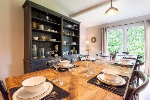 una sala da pranzo con un grande tavolo in legno con sedie di La Limetière a Neuvy-le-Roi
