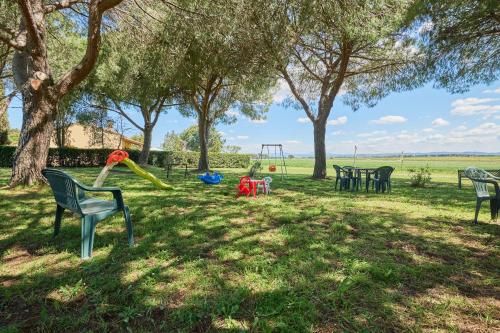 a park with chairs and a playground with trees at Mare Etrusco 5 in Populonia