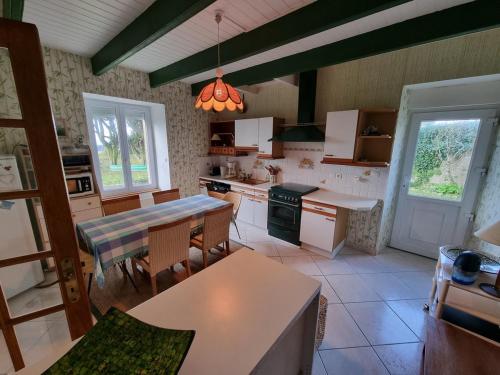 une cuisine avec une table et une salle à manger dans l'établissement 712-Villa Lezarouan a 300m des plages, à Plouhinec
