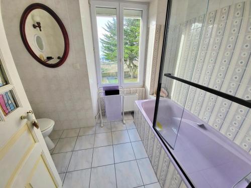 une salle de bain avec baignoire et toilettes et une fenêtre dans l'établissement 712-Villa Lezarouan a 300m des plages, à Plouhinec