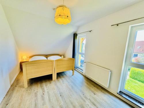 Schlafzimmer mit einem Bett und einem Fenster in der Unterkunft Ferienhaus Stoertebeker in Warnemünde