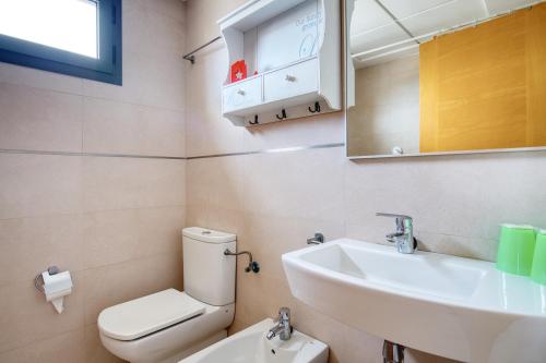 ein Badezimmer mit einem Waschbecken, einem WC und einem Spiegel in der Unterkunft Platinum Lerida in Benidorm