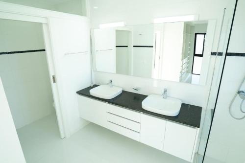 ein Badezimmer mit 2 Waschbecken und einem Spiegel in der Unterkunft New Luxury PH w/ Pool. Ocean, Mountain & City View in Mindelo
